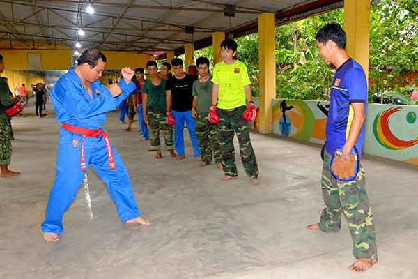 Đại tá Vũ Văn Điền (trái) hướng dẫn các động tác cho cán bộ, chiến sĩ trước khi bước vào tập luyện. Ảnh: Đ.Tùng