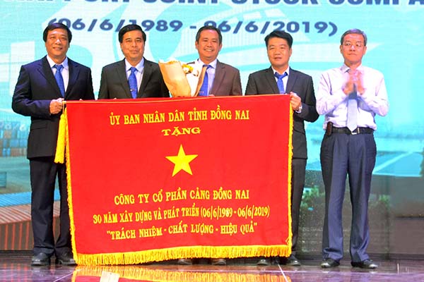 Chủ tịch UBND tỉnh Đinh Quốc Thái (ngoài cùng bên phải) tặng bức trướng của UBND tỉnh cho tập thể PDN