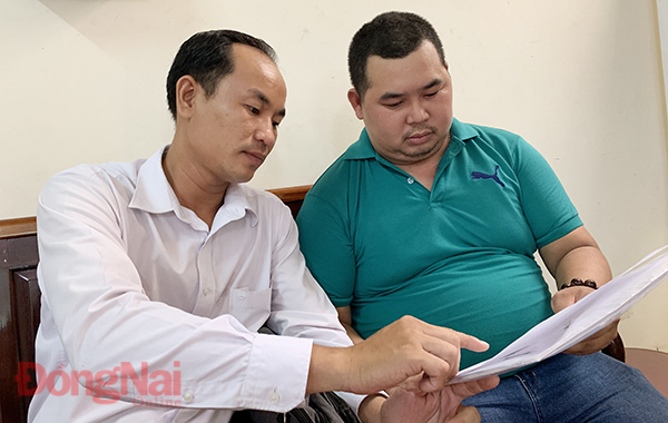 Ông Nguyễn Hoang Đưc Vinh (bên phải) đang trao đổi với luật sư sau buổi chất vấn ngay 4-6 tại Toa an nhân dân tỉnh Anh: M.QUÂN