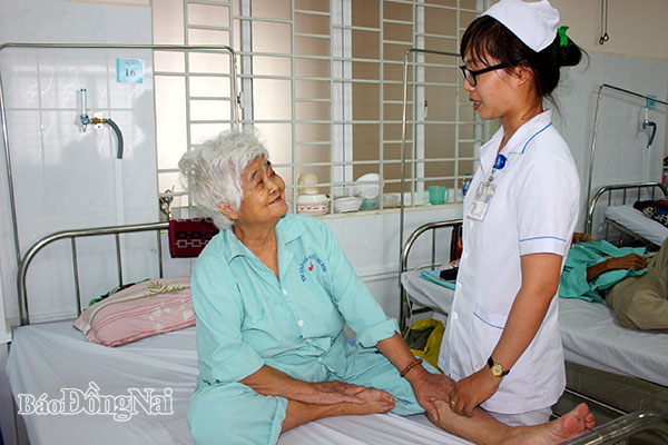 Điều dưỡng Bệnh viện đa khoa khu vực Long Khánh thăm hỏi sức khỏe của bà Bùi Thị Loan (ngụ xã Hàng Gòn, TP.Long Khánh)