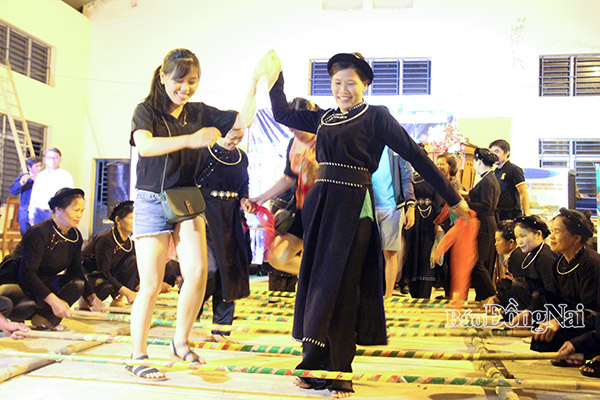 Du khách nhảy sạp cùng với dân tộc Tày khi tham quan Vườn quốc gia Cát Tiên. Ảnh: H.Quân