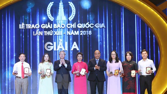 Các tác giả, đại diện nhóm tác giả nhận giải A Giải Báo chí Quốc gia lần thứ 13. (Ảnh: Minh Hiếu/Vietnam+)