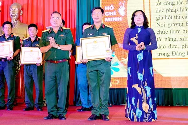 Trung tá Lê Ngọc Chánh (giữa) nhận giấy khen của Đảng ủy Quân sự tỉnh về thành tích xuất sắc trong 5 năm thực hiện Cuộc vận động Phát huy truyền thống, cống hiến tài năng, xứng danh Bộ đội Cụ Hồ trong lực lượng vũ trang tỉnh (2014-2019). Ảnh: M.Thành