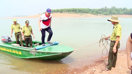 Lực lượng kiểm lâm xuống ca nô kiểm tra vùng đất bán ngập trên lòng hồ Trị An. Ảnh: T.TÂM