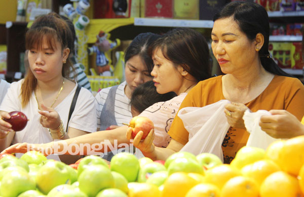 Khách hàng sử dụng túi ny-lông để đựng trái cây tại một siêu thị ở TP.Biên Hòa. Ảnh: L.Phương