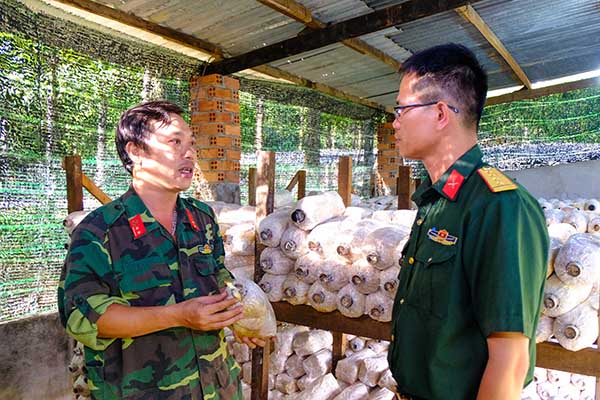 Trung úy Nguyễn Văn Xuân (trái) giới thiệu cho cán bộ đơn vị bạn đến tham quan mô hình trồng nấm của Lữ đoàn Công binh 25. Ảnh: Đ.Tùng