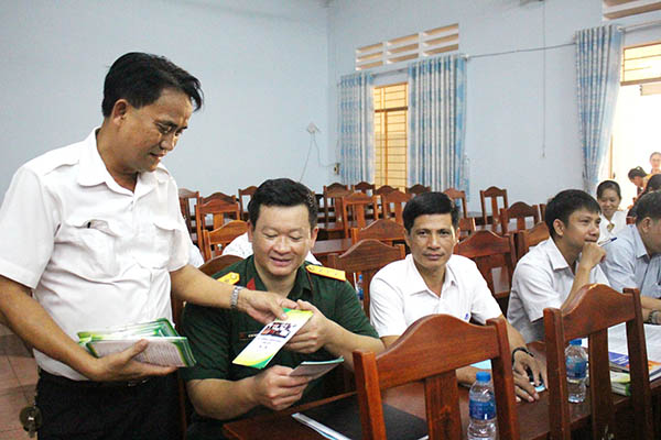 Trợ giúp viên pháp lý Nguyễn Doãn Nhương phát tờ rơi truyền thông hoạt động trợ giúp pháp lý cho cán bộ, công chức huyện Trảng Bom. Ảnh: Đ.PHÚ