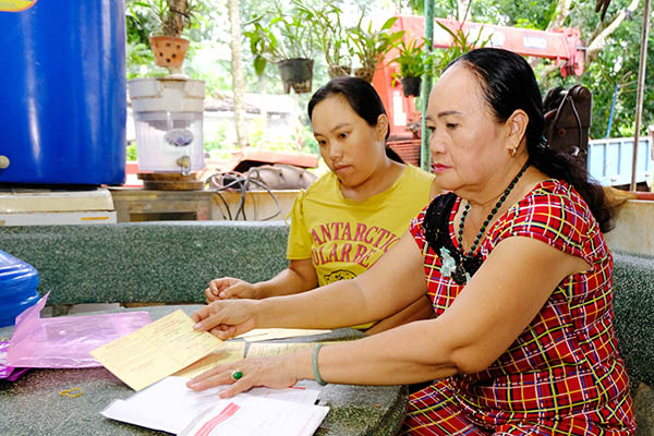 Bà Hoàng Thị Đặng (phải) với con gái Hoàng Thị Ngọc Dung sắp xếp lại các giấy chứng nhận hiến máu của gia đình. Ảnh: Đ.Tùng