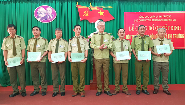Ông Võ Văn Tỉnh quyền Cục trưởng Cục Quản lý thị trường Đồng Nai thay mặt Tổng cục Quản lý thị trường trao các quyết định bổ nhiệm cho các đội trưởng đội quản lý thị trường. (Ảnh: Hoàng Hải)
