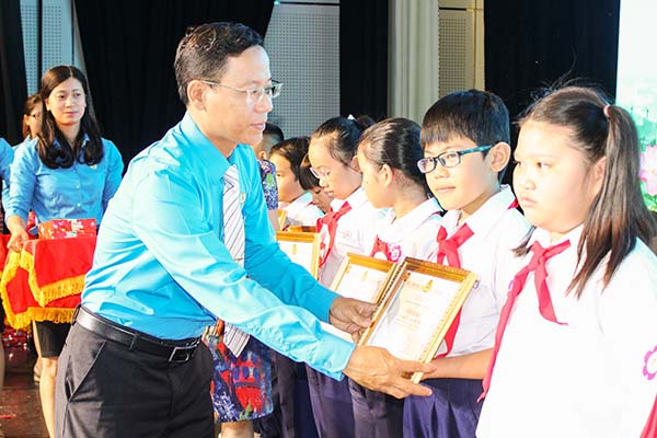 Chủ tịch Công đoàn Viên chức tỉnh Phạm Văn Chiến tặng giấy khen cho các em học sinh.