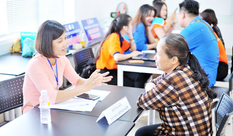 Một phụ huynh tìm hiểu thông tin ngành học trước khi đăng ký cho con xét tuyển vào Trường đại học Lạc Hồng