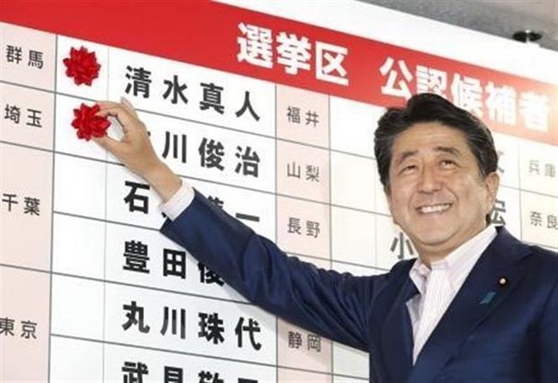 Thủ tướng Nhật Bản, Shinzo Abe gắn những bông hồng nhỏ bên cạnh tên của các ứng cử viên thắng cử của Đảng LDP sau cuộc bầu cử Thượng viện ở Tokyo ngày 21-7. (Nguồn: Kyodo/TTXVN)