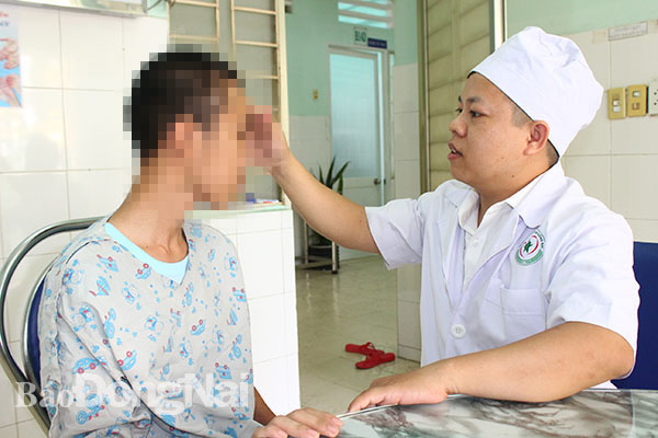Bác sĩ Toàn thăm khám chỗ vết thương trên đầu cho bệnh nhân P. trước khi bệnh nhân được xuất viện.