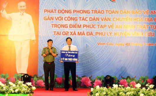 Đại tá Huỳnh Tiến Mạnh, Giám đốc Công an tỉnh trao bảng tượng trưng 3,5 tỷ đồng cho UBND huyện Vĩnh Cửu trong đợt dân vận