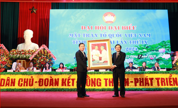 Phó chủ tịch Ủy ban Trung ương MTTQ Việt Nam Nguyễn Hữu Dũng (phải) tặng bức tranh cho lãnh đạo Ủy ban MTTQ tỉnh.