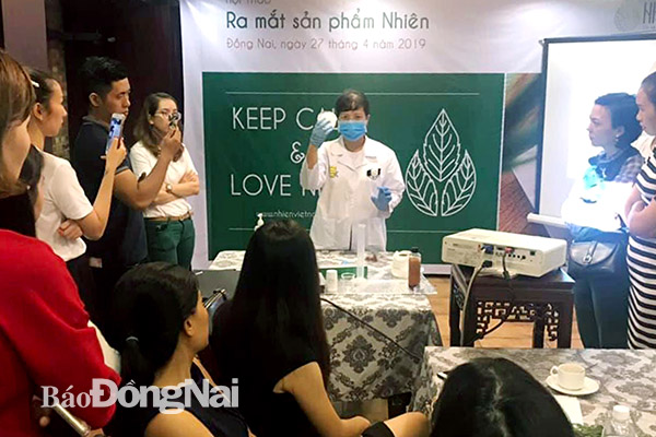 Chị Hoàng Thị Kim Anh (giữa) giới thiệu sản phẩm dầu gội Nhiên tại TP.Biên Hòa