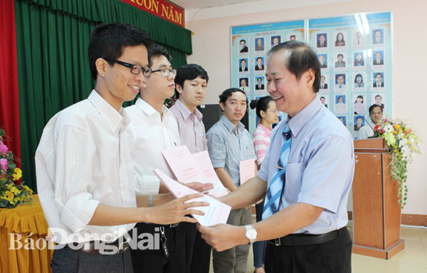 Nguyên Giám đốc  Sở Y tế Huỳnh Minh Hoàn trao quyết định phân công công tác cho các tân bác sĩ theo chương trình đào tạo theo địa chỉ của tỉnh năm 2016. ảnh: Ngọc Thư