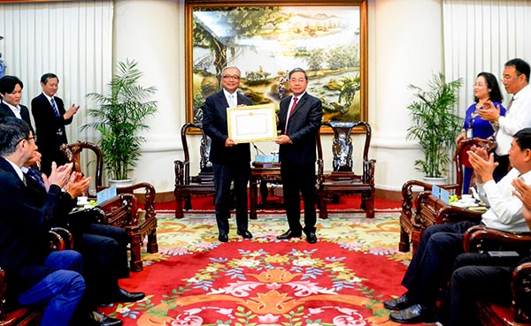 Phó chủ tịch UBND tỉnh Nguyễn Quốc Hùng (bên phải) trao bằng khen cho Công ty Vedan
