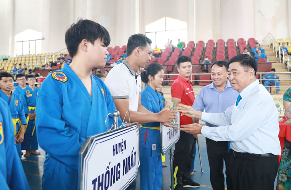 Võ sư Trần Văn Mỹ, Phó chủ tịch Liên đoàn Vovinam Việt Nam tặng cờ lưu niệm, kỷ niệm chương cho các đơn vị tham dự giải