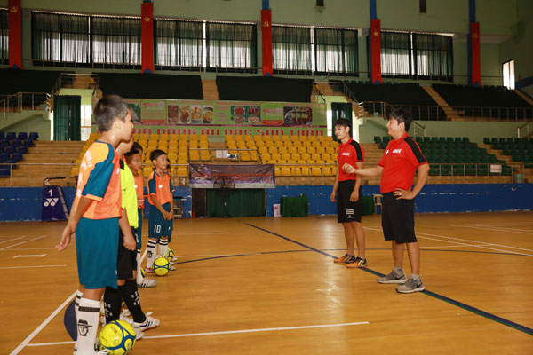 HLV Ngô Hòa Anh đang hướng dẫn chiến thuật cho các cầu thủ đội nhi đồng TP.Biên Hòa trong buổi làm quen sân Nhà thi đấu Trung tâm huấn luyện và thi đấu TDTT tỉnh sáng 11-8.