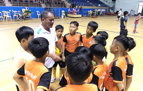 HLV Trần Văn Tuấn đang chỉ đạo các cầu thủ đội đương kim vô địch huyện Cẩm Mỹ trong buổi làm quen sân Nhà thi đấu Trung tâm huấn luyện và thi đấu TDTT tỉnh chiều 12-8