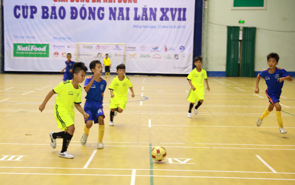 Pha tranh bóng của hai đội Thống Nhất và Vĩnh Cửu (áo xanh dương)