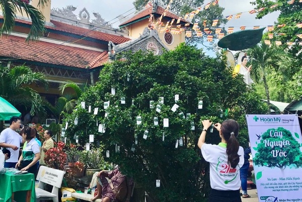 Người dân gắn phiếu nguyện ước lên cây nguyện ước tại chùa Đại Giác.