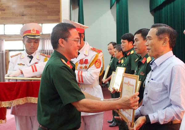 Đại tá Trần Văn Khương, Phó chính ủy Bộ Chỉ huy quân sự tỉnh tặng giấy khen cho các đơn vị thực hiện tốt Nghị định 26/2002/NÐ-CP ngày 21-3-2002 của Chính phủ. Ảnh: Cù Thuận