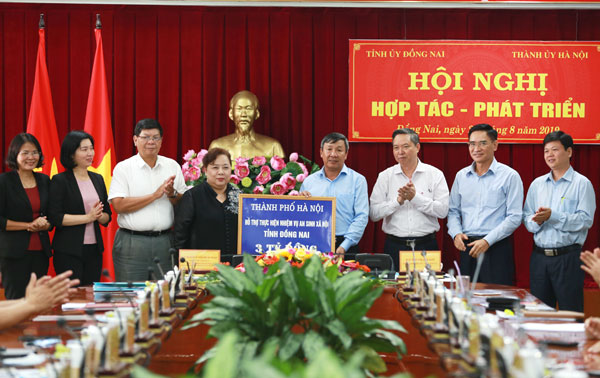 Phó Bí thư Thành ủy, Chủ tịch HĐND thành phố Hà Nội Nguyễn Thị Bích Ngọc trao số tiền 3 tỷ đồng hỗ trợ an sinh xã hội ở Đồng Nai. Ảnh: Huy Anh