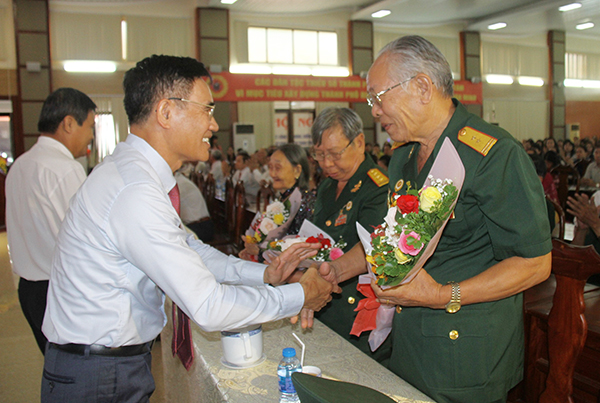 Đồng chí Trần Văn Vĩnh tặng hoa các Bà mẹ Việt Nam anh hùng, Anh hùng lực lượng vũ trang nhân dân của thành phố về dự lễ