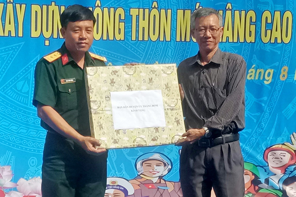 Trưởng ban Dân vận Huyện ủy Trảng Bom Trương Tấn Sĩ tặng quà cho đại diện Trường Đại học Nguyễn Huệ