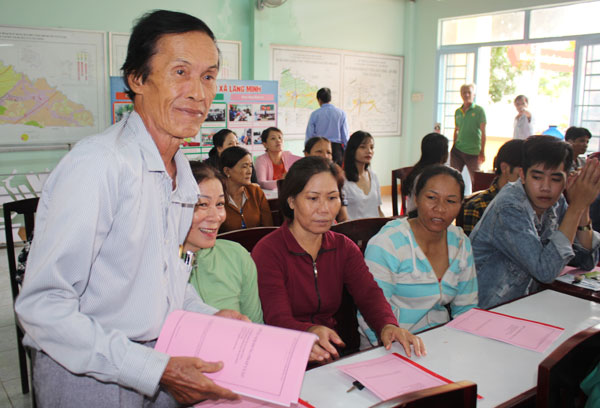 Luật gia Lê Văn Nhân, Hội Luật gia tỉnh phát tài liệu tuyên truyền về Luật Hôn nhân và gia đình năm 2014 cho đồng bào dân tộc thiểu số ở xã Lang Minh (huyện Xuân Lộc). Ảnh: Đoàn Phú