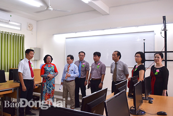 Bà Huỳnh Lệ Giang, Giám đốc Sở GD-ĐT cùng các đại biểu đi thăm các phòng học của trường THPT Chu Văn An