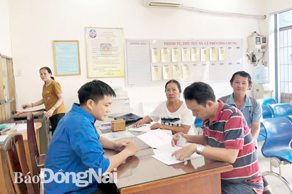 Cán bộ công chức trẻ Sở Tư pháp hỗ trợ người dân giải quyết thủ tục hành chính tại Phòng Công chứng số 1, TP.Biên Hòa. Ảnh: N.HẠ
