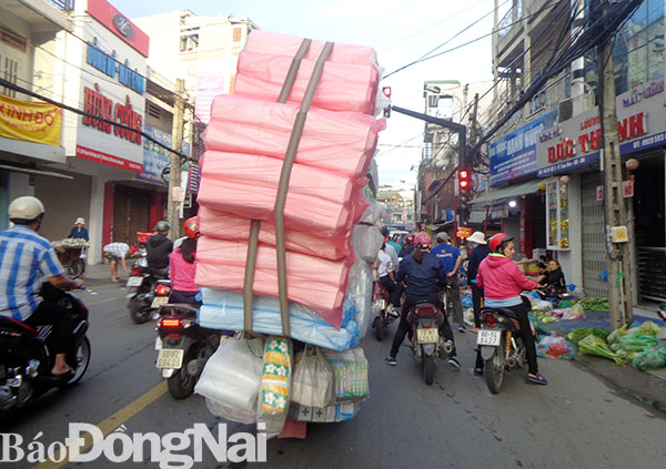 Một xe máy chở hàng cồng kềnh lưu thông trên đường Phạm Văn Thuận (phường Tam Hòa, TP.Biên Hòa)