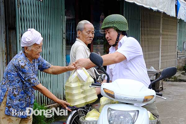 Ông Hồ Văn Dũng chở cơm phát miễn phí cho những người khó khăn trên địa bàn xã