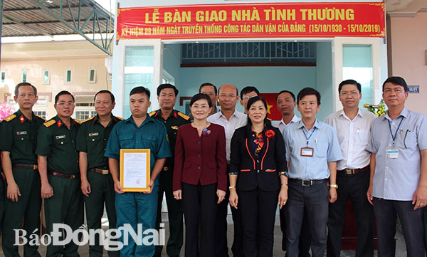 Dân quân thường trực Dương Tuấn Anh nhận quyết định tặng nhà chụp hình lưu niệm với đoàn tặng nhà