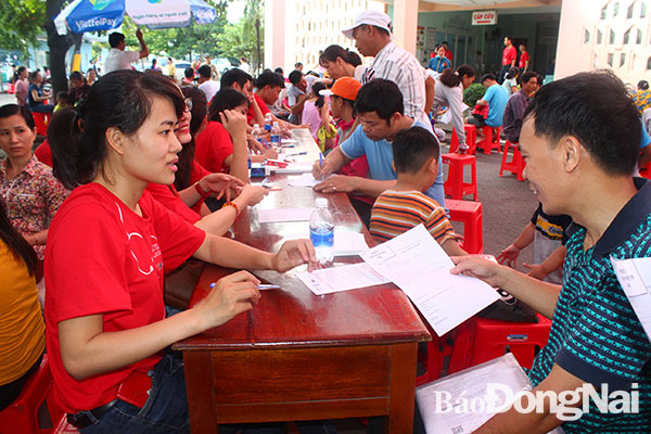 Người dân đăng ký khám sàng lọc cho con tại quầy đăng ký