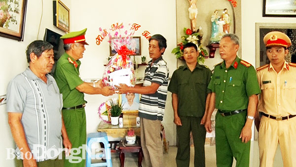 Thượng tá Lê Đình Thôn - Phó trưởng ban thường trực Ban ATGT huyện Thống Nhất trao tặng quà cho các gia đình nạn nhân. Ảnh: Bá Trực