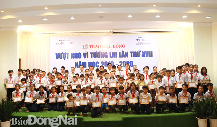 Các đại biểu, lãnh đạo báo Đồng Nai, đại diện nhà tài trợ chụp hình lưu niệm với các em học sinh được nhận học bổng
