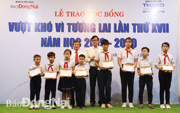 Tổng biên tập Báo Đồng Nai Nguyễn Tôn Hoàn và ông Nguyễn Một, Giám đốc truyền thông Công ty cổ phần Trường Hải trao học bổng cho các em học sinh.