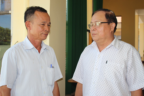 Ông Phạm Bá Thú (phải) trao đổi tình hình công tác vận động quà Tết cho người nghèo với Phó trưởng ban Tuyên giáo Đảng ủy xã Hố Nai 3 Nguyễn Ngọc Sơn