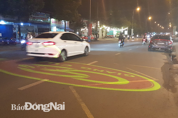 Hình ảnh logo của một quán ăn được chiếu thẳng xuống mặt đường Võ Thị Sáu (TP.Biên Hòa). Ảnh:L.Phương