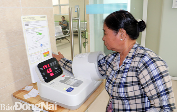 Người dân tự đo huyết áp bằng máy đo huyết áp tự động tại Bệnh viện đa khoa Đồng Nai