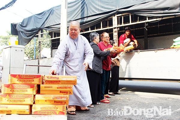 Một số hội viên Hội từ thiện tỉnh Đồng Nai chuyển hàng lên xe cho chuyến thăm và tặng quà