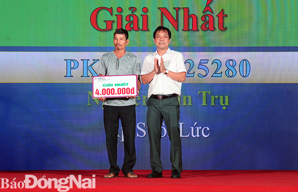 Ông Trương Đình Quốc, Phó giám đốc kinh doanh của PC Đồng Nai tặng giải nhất cho khách hàng tham gia chương trình Cài app chăm sóc khách hàng ngay, trúng quà tặng liền tay