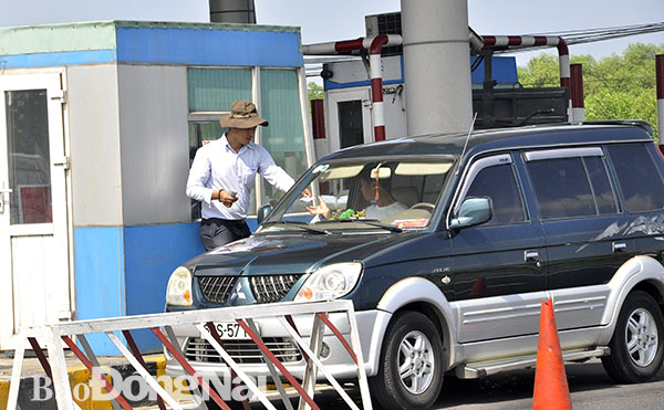 Nhân viên bán vé thủ công nhằm giải tỏa kẹt xe tại Trạm thu phí T2 trên quốc lộ 51 (đoạn qua xã Long Phước, huyện Long Thành). Ảnh: T.Hải