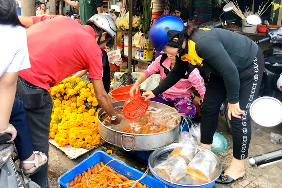 Người dân mua cá chép về cúng ngày 23 tháng Chạp tại chợ Biên Hòa vào chiều 16-1 (tức 22 tháng Chạp). (Ảnh: Lam Phương)