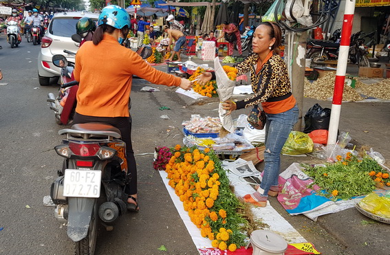 Người dân chọn mua hoa cúng ở khu vực chợ Biên Hòa. (Ảnh: Lam Phương)
