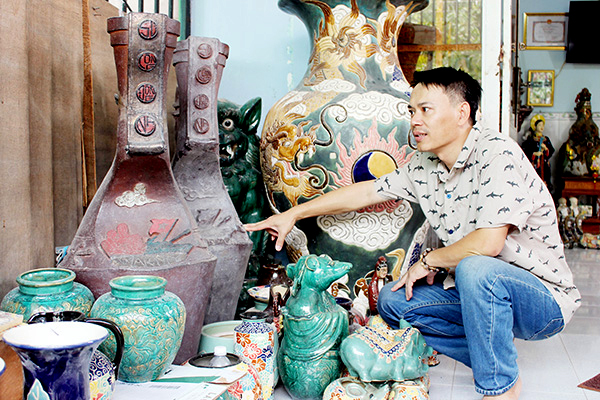 Ông Hoàng Ngọc Hiến, chủ Cơ sở gốm Phú Hiến Nam (phường Hóa An, TP.Biên Hòa) bên các sản phẩm gốm mỹ nghệ